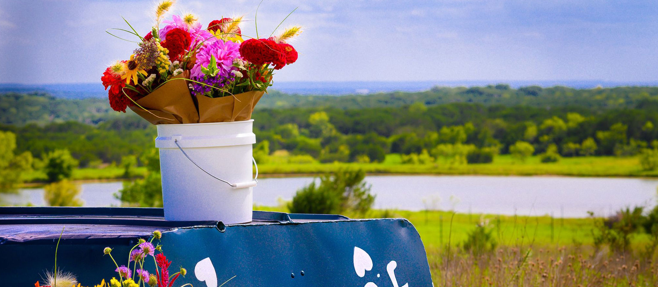 Two buckets of flowers sitting on a boat.